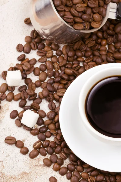 Granos de café, taza y olla en el saqueo — Foto de Stock