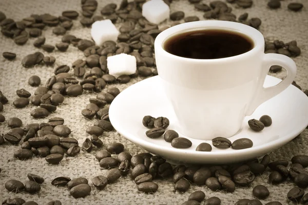 Чашка кофе, бобы на мешке — стоковое фото