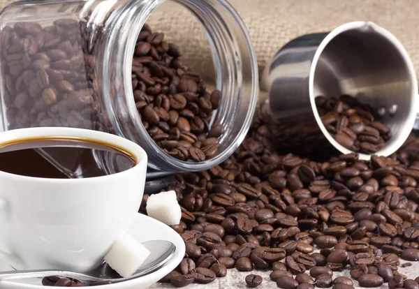 Kopp kaffe, bönor och kvarnen på säckväv — Stockfoto