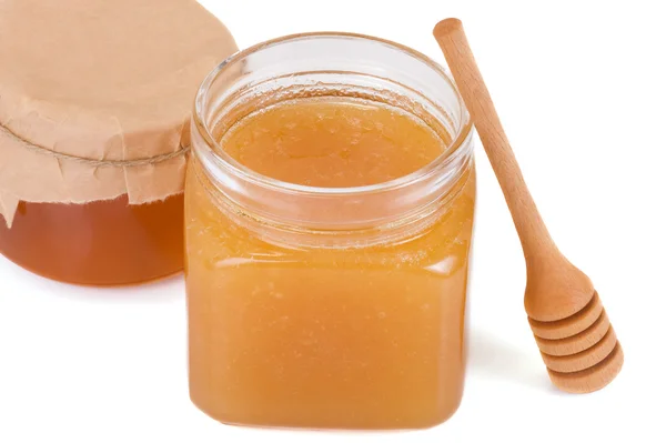 Glass pots with honey and stick — Stock Photo, Image