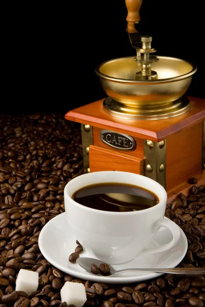 Tasse Kaffee und Mühle auf Bohnen — Stockfoto