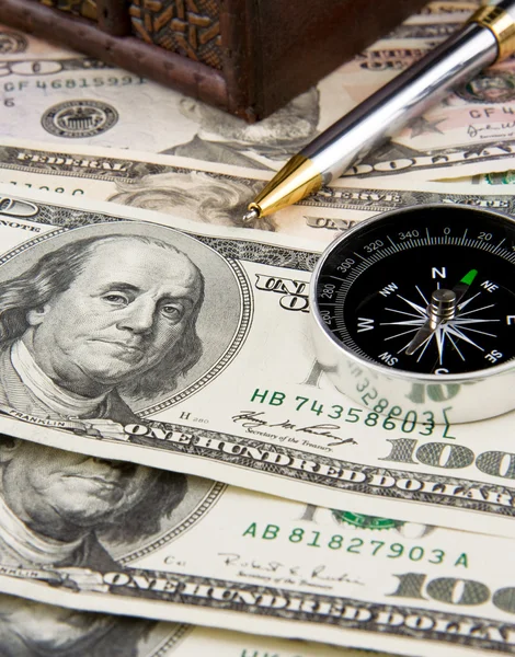Чернильная ручка и компас на долларах — стоковое фото