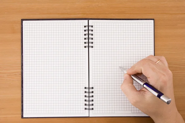 Hand skriva med penna på anteckningsboken — Stockfoto