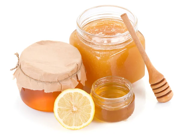 Olla llena de miel y limón aislada en blanco — Foto de Stock