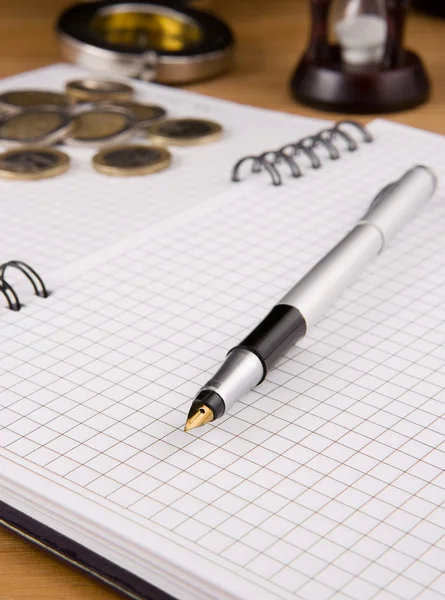 Στυλό και κέρμα στο σημειωματάριο — Φωτογραφία Αρχείου