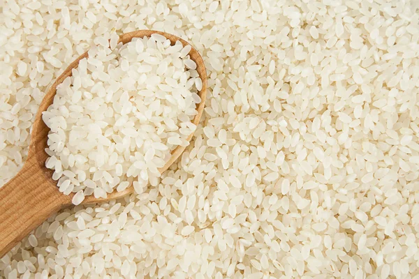 Reishintergrund und Kochlöffel — Stockfoto
