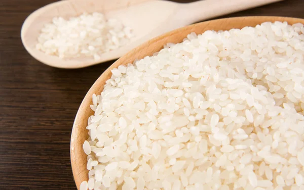 Rýže a deska s dřevěnou lžící — Stock fotografie