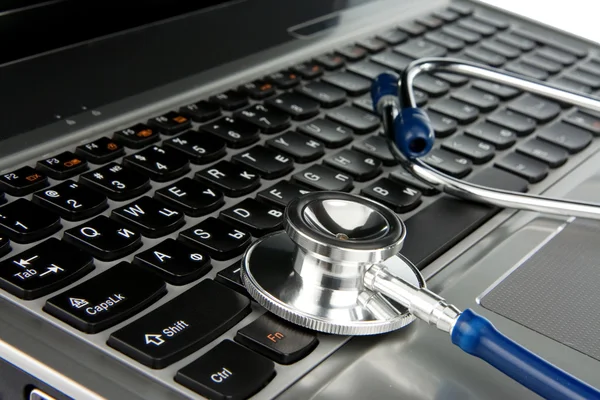 Notebook laptop üzerinde beyaz izole stetoskop — Stok fotoğraf