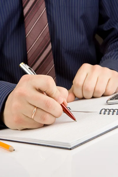 Hand skriva med penna på kontrolleras anteckningsboken — Stockfoto