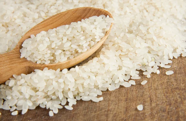 Rijst graan in houten lepel — Stockfoto