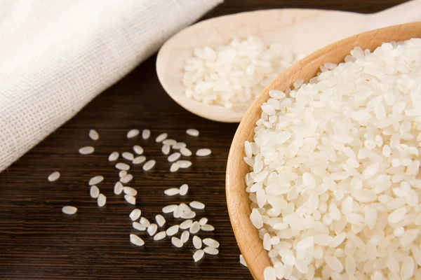 Grano di riso e piatto di legno — Foto Stock