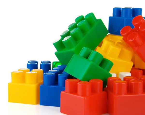 Kolorowe zabawki z tworzyw sztucznych i cegieł na białym tle — Zdjęcie stockowe