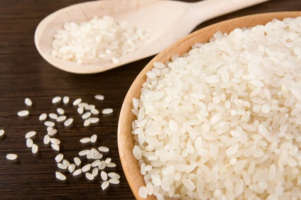 Рис в деревянной тарелке и ложке — стоковое фото