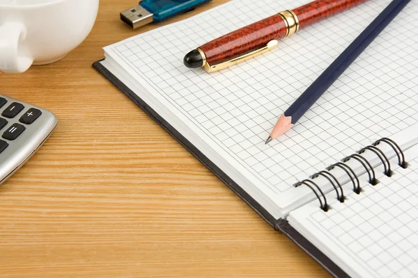 Kopp kaffe, kalkylator och penna på anteckningsboken — Stockfoto