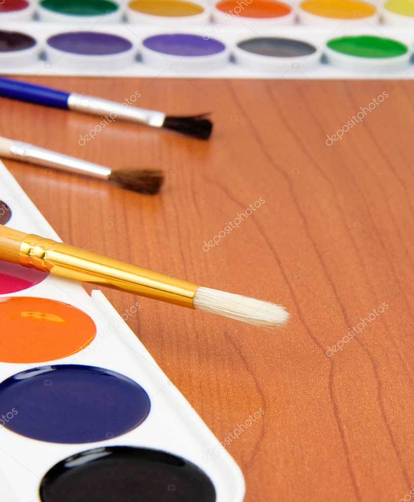 Paint brush and painters palette on table Stock Photo by ©seregam