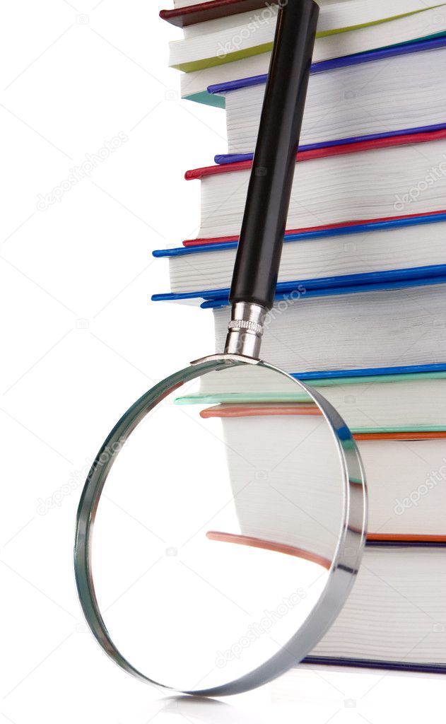 Pile of new books and magnifying glass isolated on white