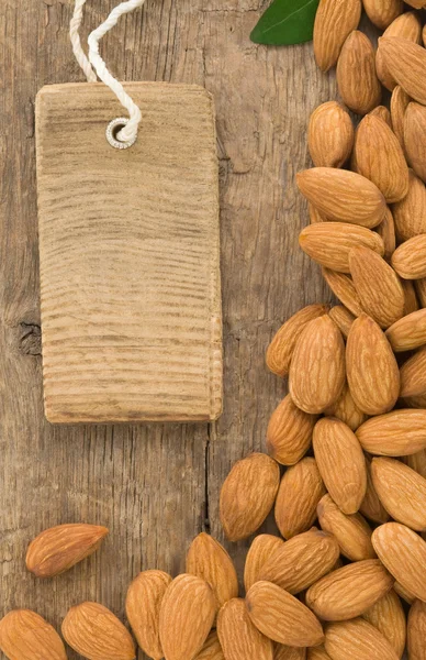 Nüsse Mandelfrüchte und Etikett auf Holz — Stockfoto