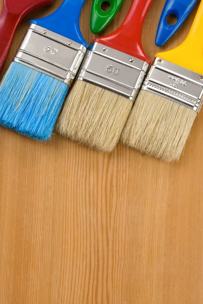 Färgglada pensel på trä bakgrund — Stockfoto