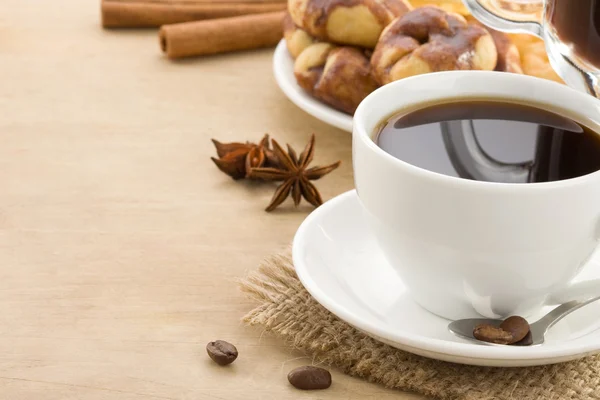 Xícara de café com feijão e bolos em madeira — Fotografia de Stock
