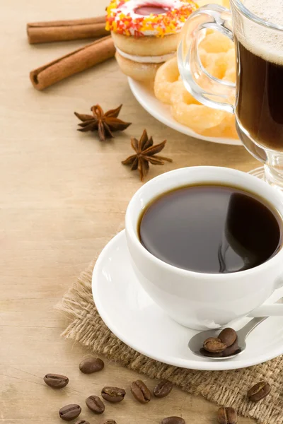 Kopp kaffe med bönor och kakor på trä — Stockfoto