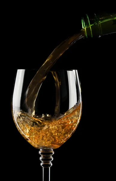 Наливание вина в бокал, изолированный на черный — стоковое фото