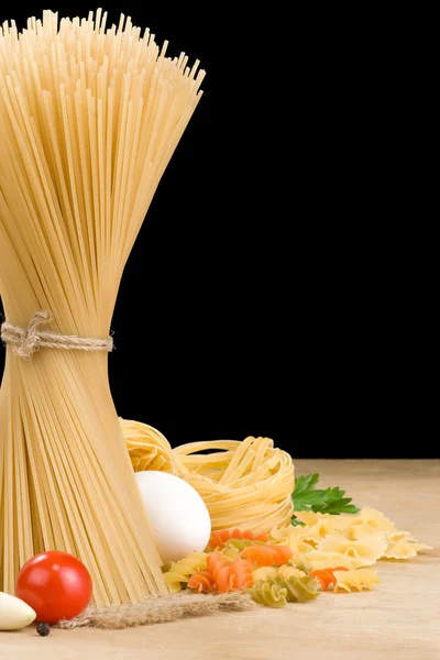 Rå pasta och mat grönsaker isolerade på svart — Stockfoto