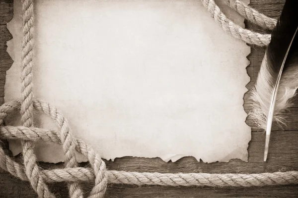 Канаты и перо на старинной старинной бумаге — стоковое фото