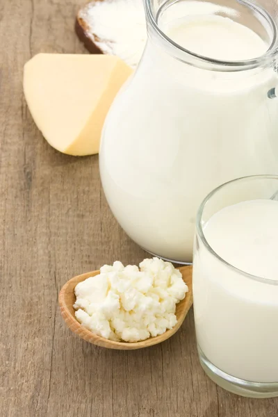Queso y productos lácteos sobre fondo de madera —  Fotos de Stock