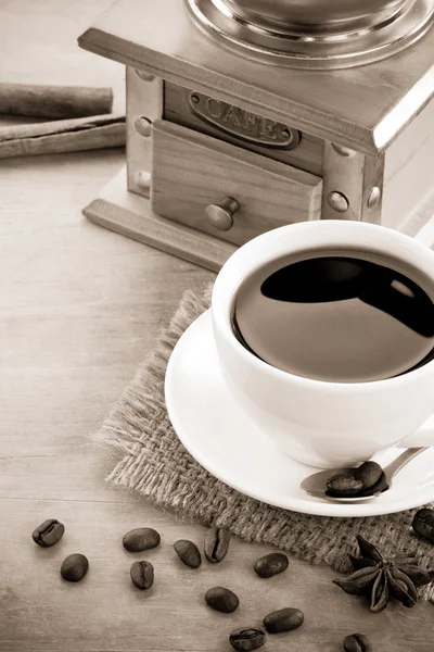 Taza de café sobre frijoles asados sobre fondo de madera — Foto de Stock