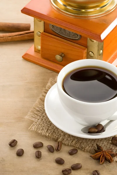 Tasse Kaffee auf gerösteten Bohnen vor Holzhintergrund — Stockfoto