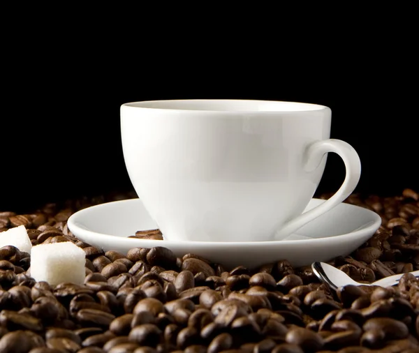 Tasse Kaffee und Bohnen auf schwarz — Stockfoto