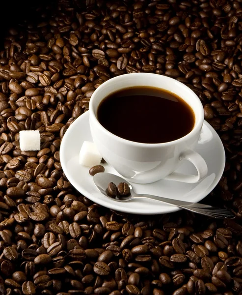 Grãos de café e xícara em preto — Fotografia de Stock