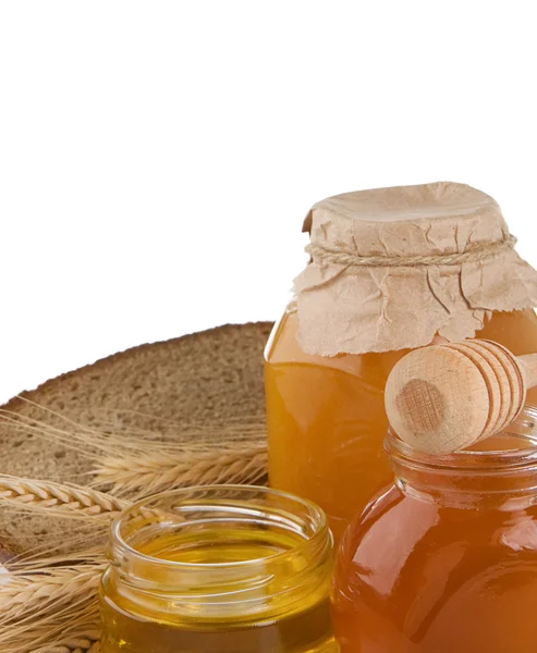 Glas van honing en geïsoleerd op wit brood — Stockfoto