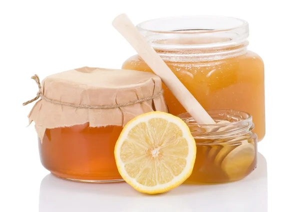 Pot full of honey and lemon isolated on white — Stock Photo, Image
