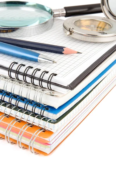 Caneta e lápis em pilha de caderno isolado em branco — Fotografia de Stock