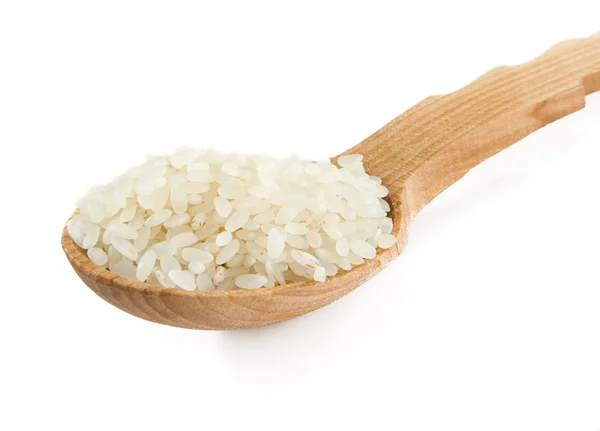 Ryż w drewnianą łyżką na białym tle — Zdjęcie stockowe