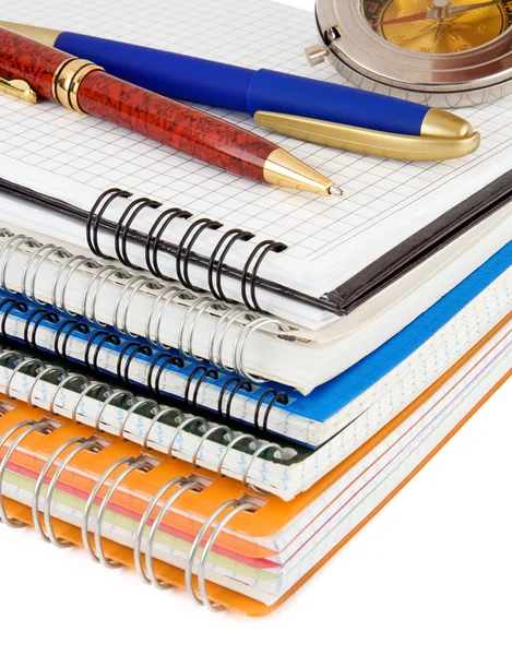 Stift und Bleistift am Stapel Notizbücher auf Weiß — Stockfoto
