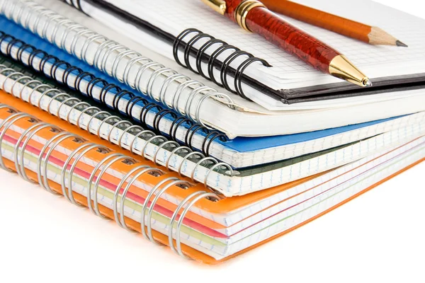 Caneta e lápis no caderno verificado isolado em branco — Fotografia de Stock