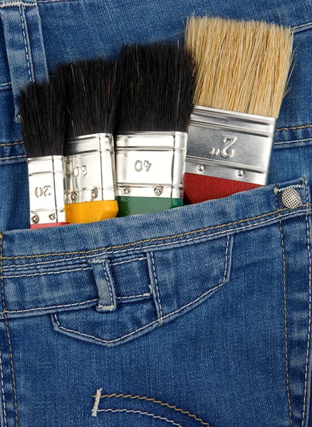 Paintbrushes on jeans texture — Stock Photo, Image