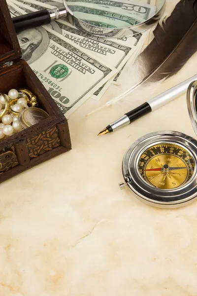 Penna, lente d'ingrandimento, piuma e bussola vicino ai dollari — Foto Stock