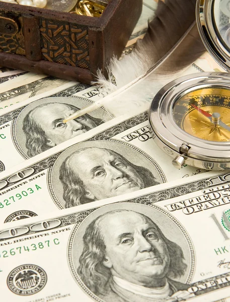 Грудь с монетами и компасом в долларах — стоковое фото