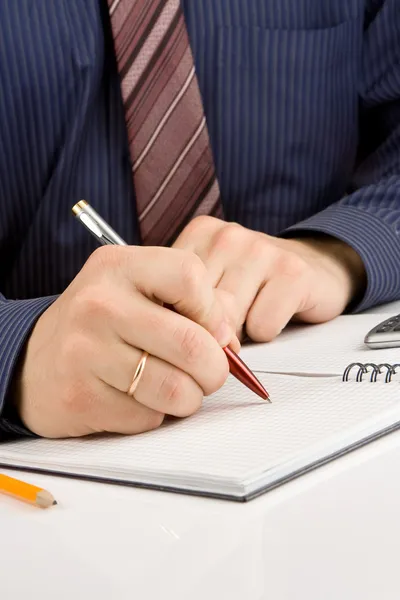 Manlig hand skriva med penna på kontrolleras anteckningsboken — Stockfoto