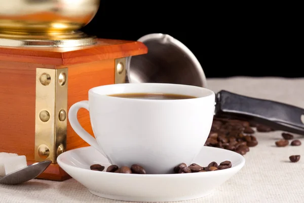 Kaffeebohnen, Tasse und Mühle beim Säcken — Stockfoto