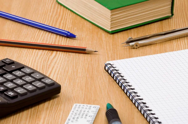 Calcolatrice penna, matita e carta con quaderno a quadretti su legno — Foto Stock