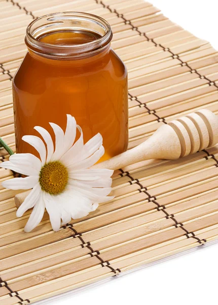 stock image Pot of honey and flower on white