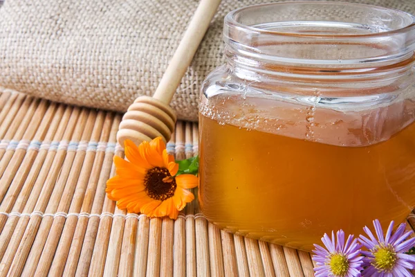 Honey in glass pot near sack — Stock Photo, Image