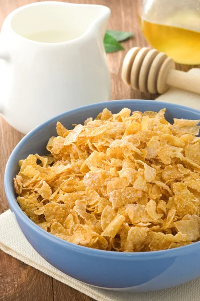 Bowl of corn flakes and milk on wood — Stock Photo, Image