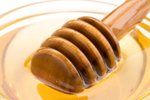 Miel en vidrio y palo aislado en blanco — Foto de Stock