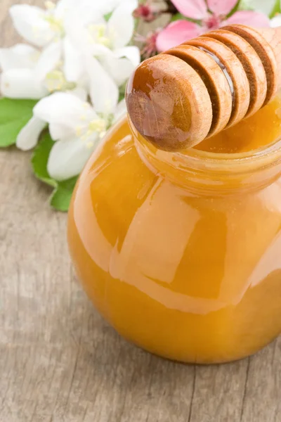 Honey in glass jar and stick — Stock Photo, Image