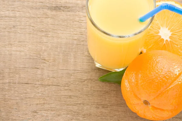 Čerstvé ovoce pomerančovou šťávu ve skle na dřevo — Stock fotografie